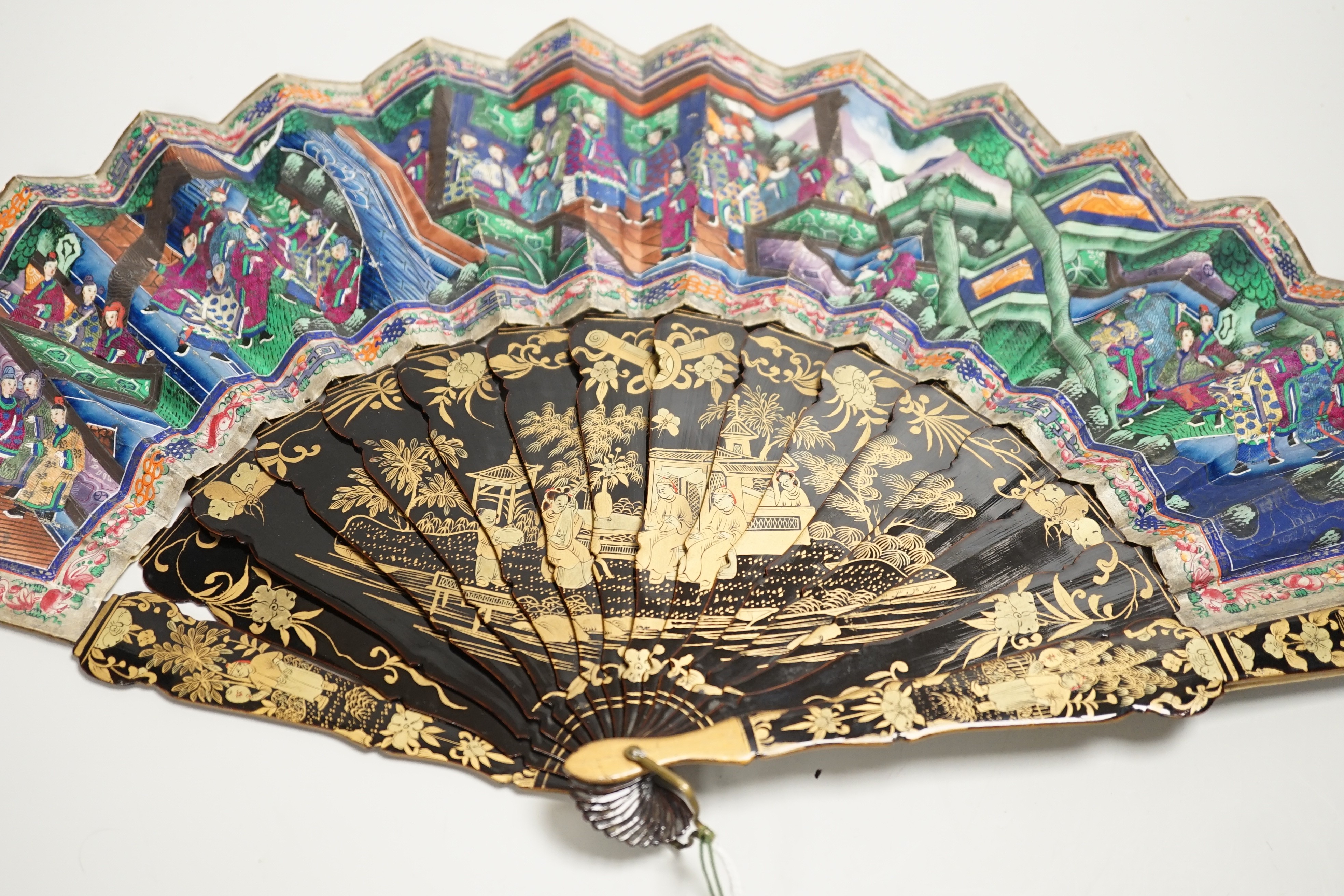 A 19th century Chinese painted paper leaf and lacquer painted fan in a gilt decorated black lacquer fitted case, the fan with painted ivory appliqué faces, 28cm